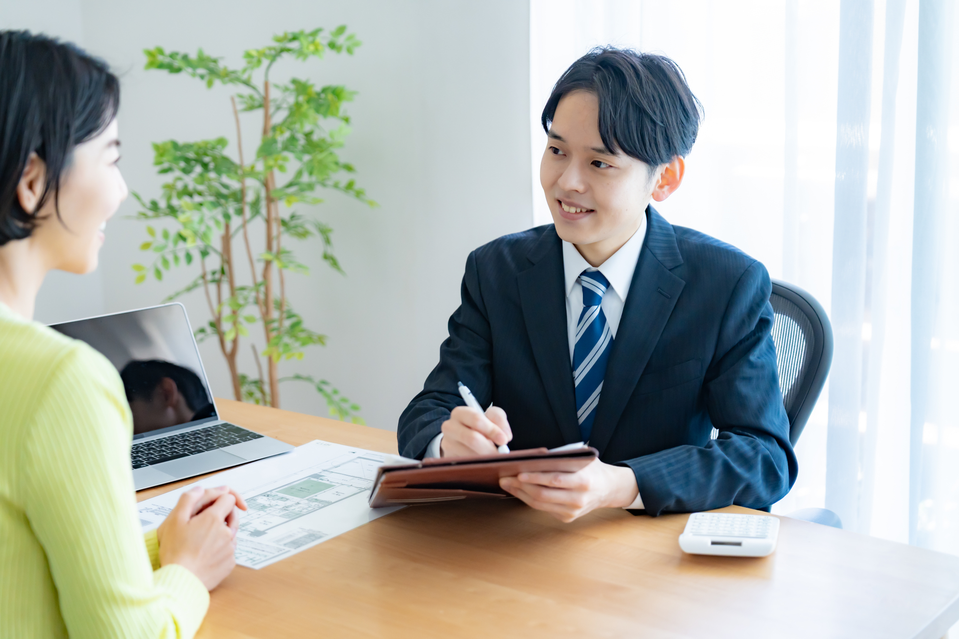 お客様と打ち合わせをする不動産担当者